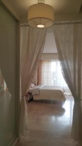 第聂伯罗基洛夫公寓酒店的一间卧室配有床和带窗帘的窗户