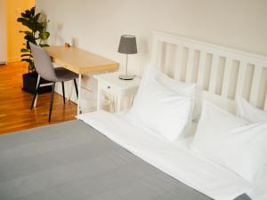利沃夫达尼罗宾馆的一间卧室配有一张带白色枕头的床和一张书桌