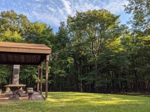 吉姆索普Chestnut Tree Lodge - Modern Wooded Escape的公园内带野餐桌的野餐棚