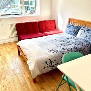 伦敦Waterloo Central London的一间卧室配有一张床和一张红色的沙发