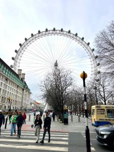 伦敦Waterloo Central London的人穿过街道的城市里的一个大型摩天轮
