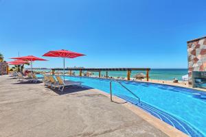 佩尼亚斯科港Sonoran SKY #910的海滩旁的游泳池配有椅子和遮阳伞