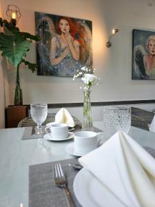 圣贝纳迪诺Hotel Oasis-Dream Holidays - La Petite France的餐桌,配有白色桌布和绘画