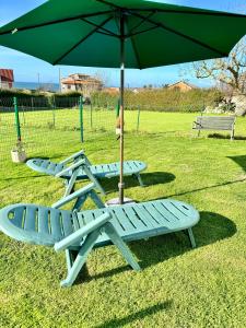 桑坦德Alojamientos Robustiana的两张野餐桌和一把带两把椅子的雨伞