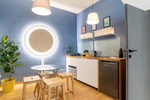 特雷维索Rialto 13的厨房拥有蓝色的墙壁,配有桌椅