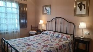 里瓦德塞利亚La Xana Ribadesella的一间卧室配有一张床、两盏灯和一个窗户。