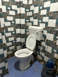 德奥加尔GRG Sunrise Plaza Deoghar的一间带卫生间和瓷砖墙的浴室