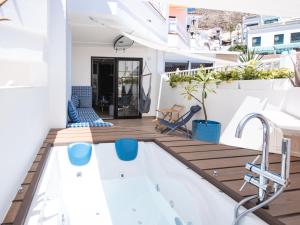 洛斯克里斯蒂亚诺斯WOW APARTMENT WITH PRIVATE JACUZZI and 2 terraces的阳台设有小型游泳池和木甲板。