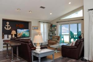 印第安帕斯WindScape by Pristine Properties Vacation Rentals的客厅配有皮革家具和大窗户