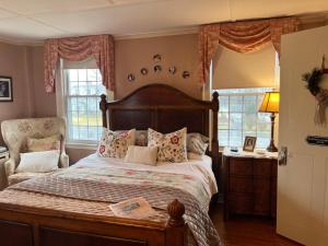 恩菲尔德Antique1242 British Bed & Breakfast的一间卧室配有一张床、一把椅子和窗户。