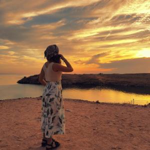阿布辛贝Safari Abu Simbel的一位站在海滩上观看日落的女人