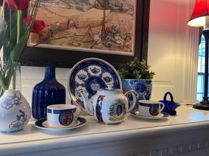恩菲尔德Antique1242 British Bed & Breakfast的上面有蓝色和白色的杯子和盘子的架子