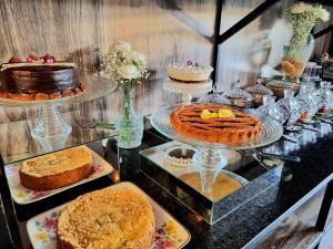 圣贝纳迪诺Hotel Oasis-Dream Holidays - La Petite France的盘子上装有蛋糕和其他甜点的展示盒