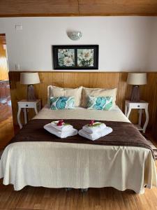安加罗阿Teanehi Bed & Breakfast的一间卧室配有一张大床和两条毛巾