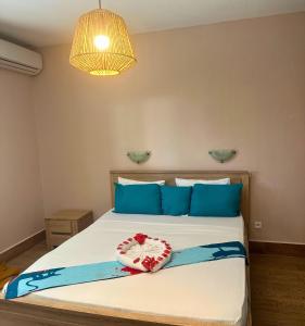 藻德济LESSENCIEL的一间卧室配有一张带蓝色枕头的大床