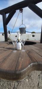 阿索马达Apartamentos Rurales Islas Canarias的木桌上放有两杯酒和一瓶酒