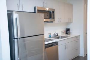 格林菲尔德THE NEST的白色的厨房配有冰箱和水槽