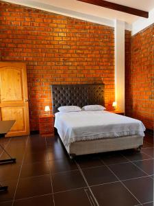 塔拉波托DELUX的一间卧室设有一张床和砖墙