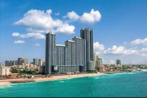 阿吉曼CMA Skyline Sanctuary Apartments - Ajman Corniche UAE的享有海滩和大海的美景,拥有高大的建筑