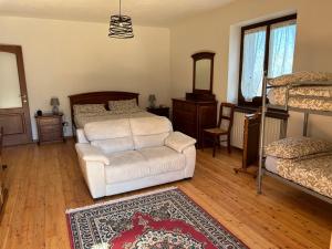 Bagnolo PiemonteCasa Salada的一间卧室配有一张床、一把椅子和地毯
