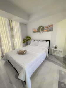 马尼拉Azure Staycation Suites by MECS的卧室配有一张白色的床,上面有篮子