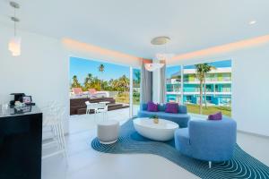 蓬塔卡纳Sunrise Miches Beach Resort, Punta Cana - All Inclusive - Adults Only的客厅配有蓝色的椅子和桌子