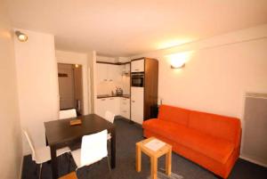 古雷特Résidence MARMOTTES - Studio pour 4 Personnes 004的客厅配有红色的沙发和桌子