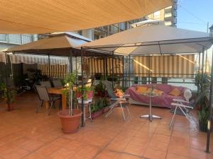 圣地亚哥Terraza Santa Lucia,Suites "Como en su Casa"的庭院配有遮阳伞和桌椅。