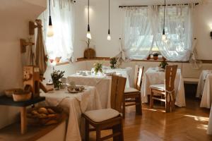 梅拉诺Hotel Villa Freiheim的一间用餐室,配有2张带白色桌布的桌子