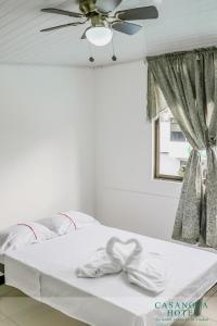 圣何塞CASANOVA HOTEL的一间卧室配有一张带吊扇和窗户的床。