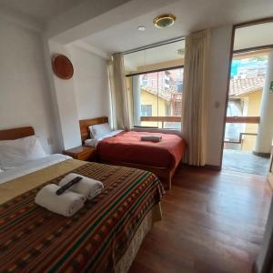库斯科奇拉坤特酒店的酒店客房设有两张床和窗户。