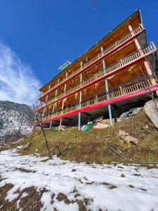 ToshPahadi Bliss Hostel ,Tosh的雪中山顶上的建筑