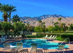 棕榈泉Modern & Uncluttered - A Ryson Property的一个带椅子的游泳池,背景是山脉