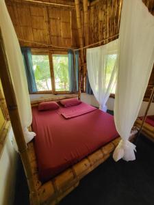 圣卡塔利娜岛Eco-Lodge Deseo Bamboo的一间设有红色床的卧室,位于带窗户的房间内