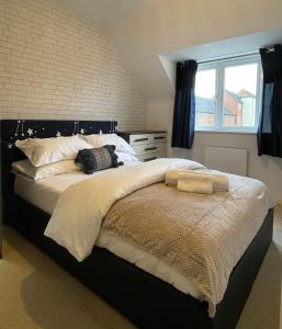 林肯Holcott's Coach-House的卧室配有一张带白色床单的大床和窗户。
