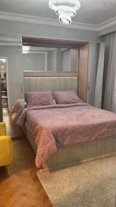 Sheikh Zayedدوبلكس اربع غرف بيفرلي هيلز ويست تاون فرش عالي جدا的一间卧室配有一张带紫色枕头的大床