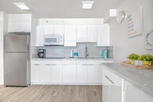 檀香山Ocean View Suite, Near Beach & Free Parking!的白色的厨房配有白色橱柜和冰箱。