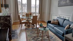奥尔良Appartement avec belle vue sur la place du Martroi的客厅配有蓝色的沙发和桌子
