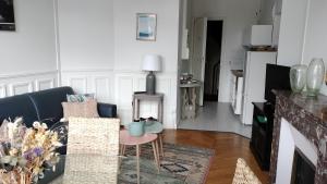 奥尔良Appartement avec belle vue sur la place du Martroi的客厅配有沙发和桌子