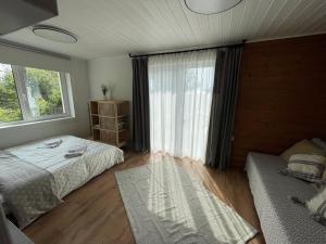 LaoSeaside Retreat with Hot tub,Sauna, Pool & BBQ的一间卧室设有两张床和窗户。