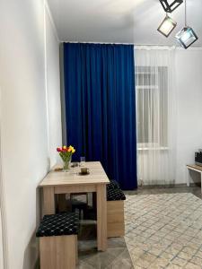 阿克套Жилой комплекс Махаббат的配有桌子和蓝色窗帘的房间