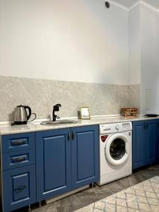 阿克套Жилой комплекс Махаббат的厨房配有蓝色橱柜和洗衣机。