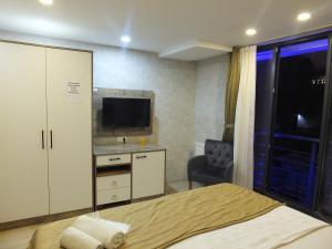 伊斯坦布尔CLOVE SİLVANA HOTEL的一间卧室配有一张床、一张书桌和一台电视。
