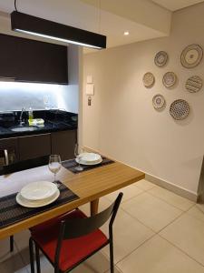 圣保罗Apartamentos & Flats La Residence Paulista的用餐室配有带盘子和酒杯的桌子