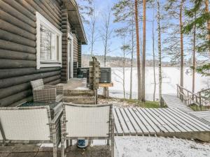 NummiHoliday Home Villa lahnajärvi by Interhome的门廊上的房子,配有两把椅子和一张桌子