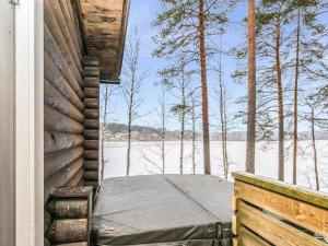 NummiHoliday Home Villa lahnajärvi by Interhome的雪景门廊上的一张床位