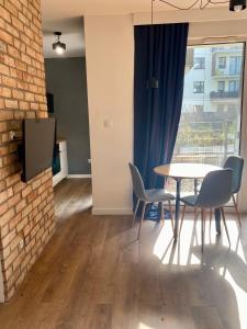 华沙Chillout Loft Apartment AL20的一间设有桌椅和砖墙的用餐室
