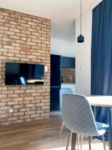 华沙Chillout Loft Apartment AL20的一间设有砖墙和桌椅的客厅