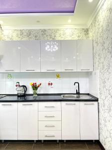 阿克套ЖК Тыныштык的白色的厨房配有白色橱柜和水槽
