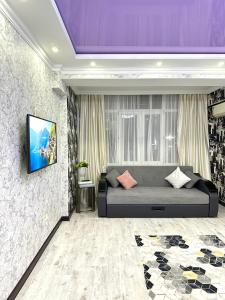 阿克套ЖК Тыныштык的一间设有床铺和墙上电视的房间